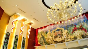 A grand chandelier, a mural with classical figures, and a red curtain in a hotel lobby. - Hotel Elizabeth Cebu (Cebu City)