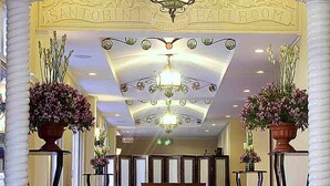 An ornate hallway with a red carpet, a chandelier, and two potted plants. - Hotel Elizabeth Baguio (Baguio)