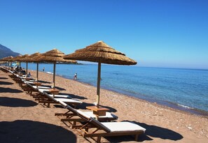 Nära stranden, solstolar, parasoller och snorkling