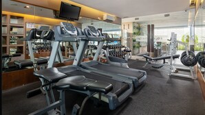 Un gimnasio moderno con cintas de correr, bancos de pesas y pesas sueltas.