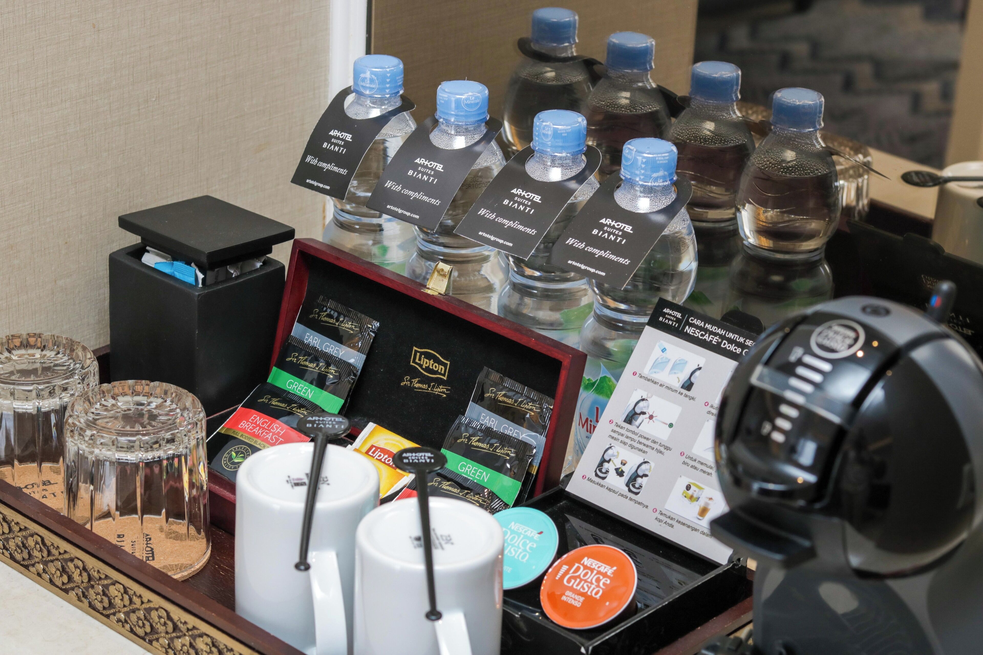 A hotel minibar with various beverages, including water, coffee, and tea.