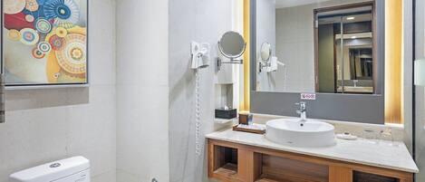 A modern bathroom with a toilet, sink, and mirror.