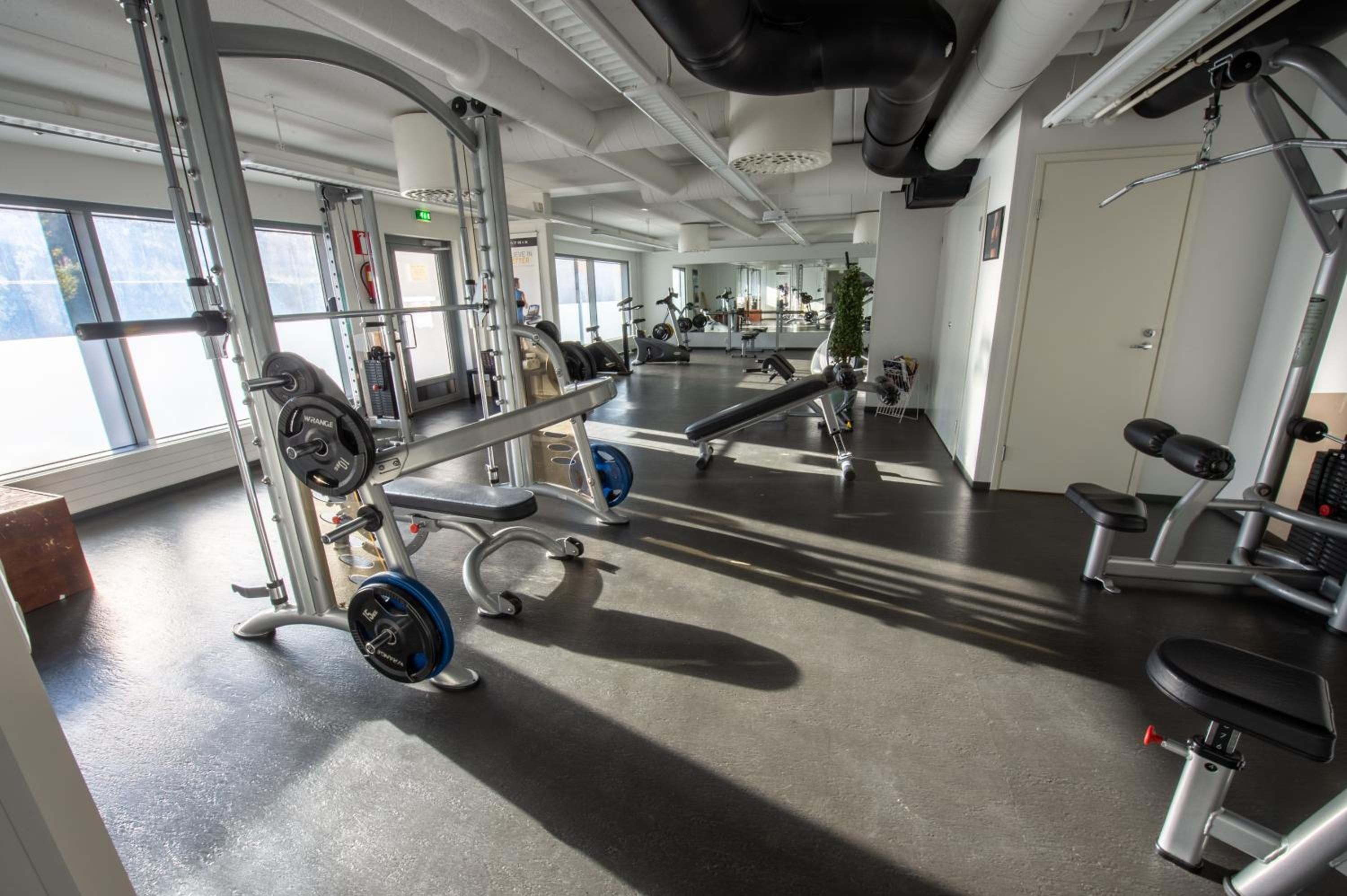 Une salle de sport équipée de matériel de musculation, de tapis de course et d’appareils d’exercice.