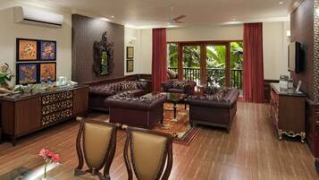 A spacious living room with leather sofas, a coffee table, and a dining area with a table and chairs.