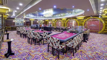 Accommodating guests with ample space for movement and seating, this room features a large chandelier and multiple tables and chairs.