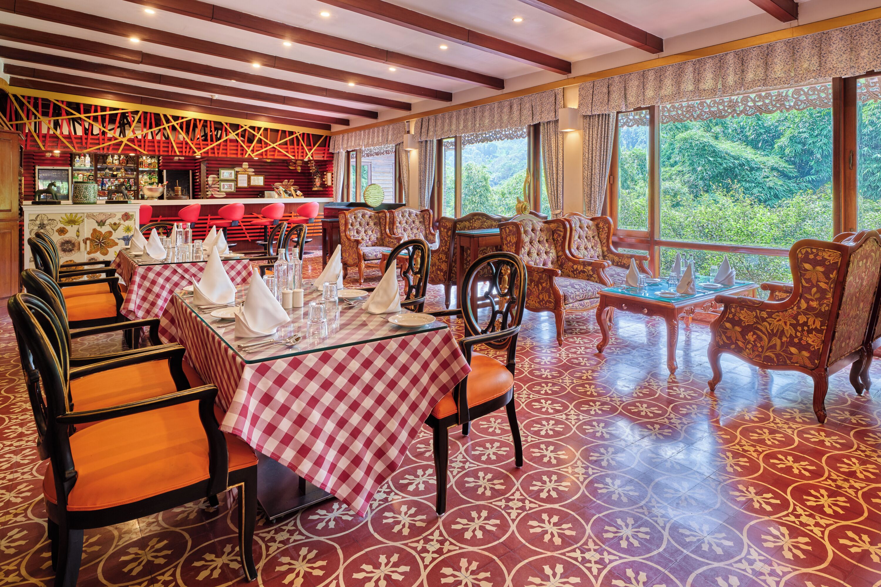 Een restaurant met geruit tafelkleed, houten stoelen en een patroon op de vloer.