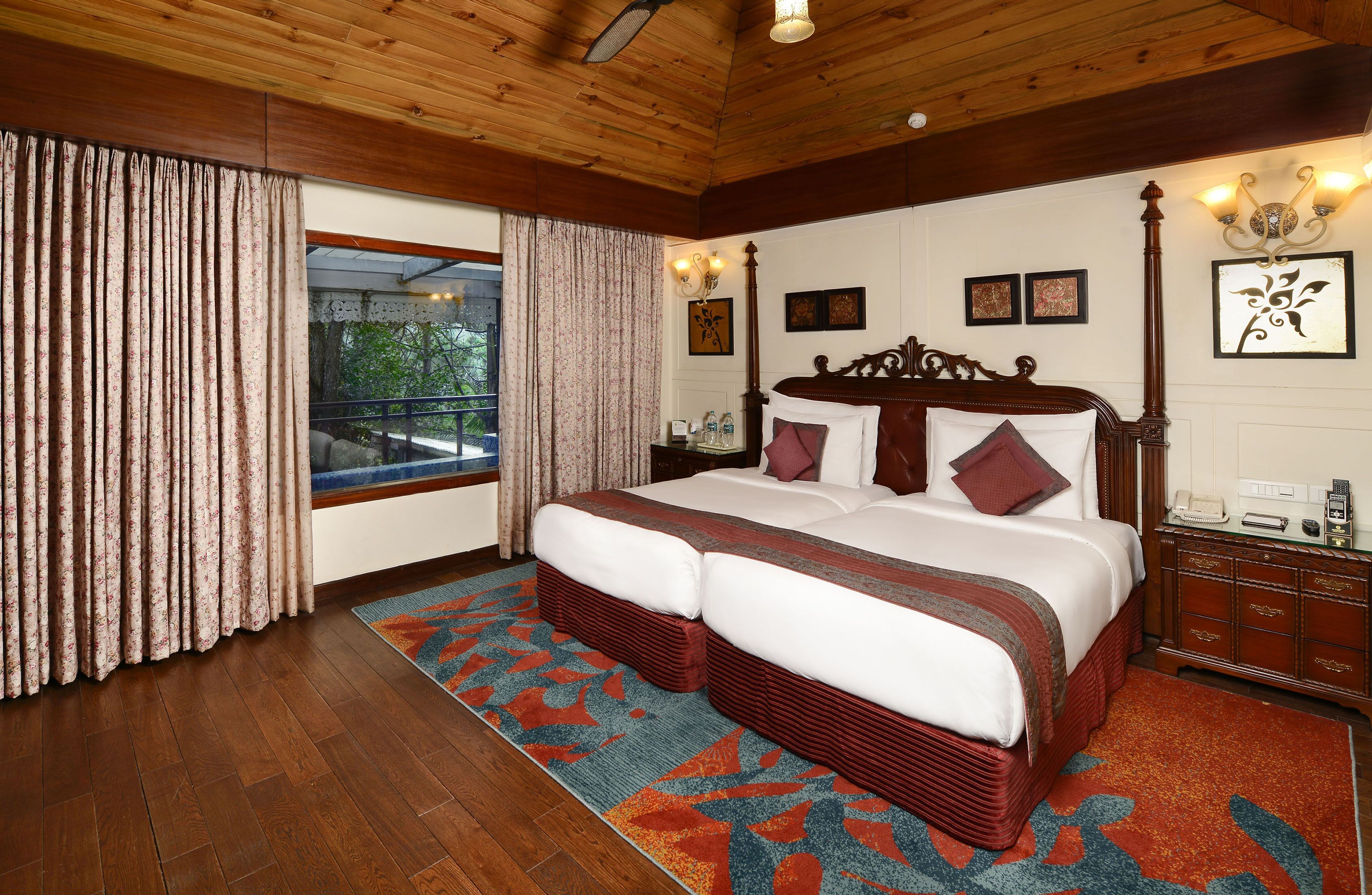 A spacious bedroom with a large bed, wooden headboard, and a view of a balcony.