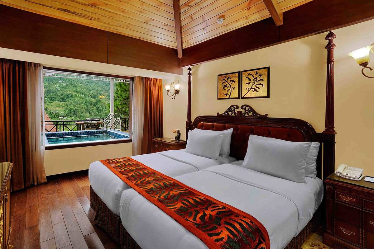 A hotel room with a large bed, a view of a pool, and a balcony.