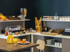 Um buffet de café da manhã com diversos alimentos e bebidas.