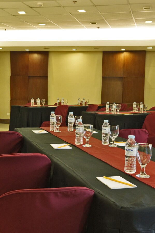 A conference room with tables set for meetings, equipped with water bottles and glasses.