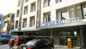 Un edificio de hotel con fachada moderna, ventanas amplias y un cartel llamativo.