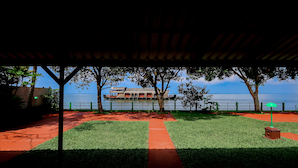 A covered outdoor area with a pathway leading to a waterfront view. - ILLIKKALAM Lakeside Cottages Kumarakom Kerala (Kottayam)