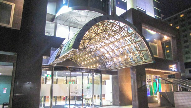 A hotel entrance with a distinctive arched glass canopy and a modern design. - HOTEL LiVEMAX Sapporo Nakajima Park GRANDE (Sapporo)