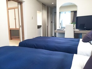 A hotel room with two beds, a desk with a computer, a television, and a mirror. - HOTEL LiVEMAX Sapporo Nakajima Park GRANDE (Sapporo)