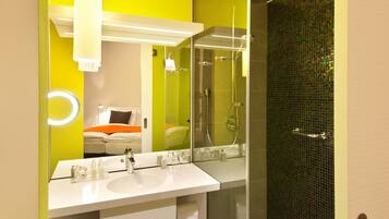 Un baño moderno con un espejo grande, lavamanos dobles y cabina de ducha.