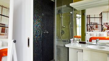 Un baño moderno con cabina de ducha de vidrio, un lavabo blanco y un espejo.