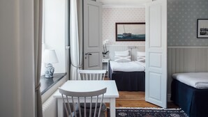 A compact bedroom with a bed, a small table, and a chair. - Kivikstrand Badhotell (Kivik)