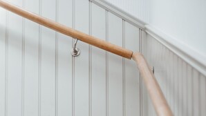 A staircase with white steps and a wooden handrail. - Kivikstrand Badhotell (Kivik)