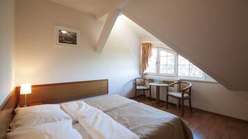 Een slaapkamer met een bed, een bureau en een stoel.