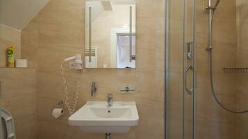Un baño con lavamanos, espejo y ducha.