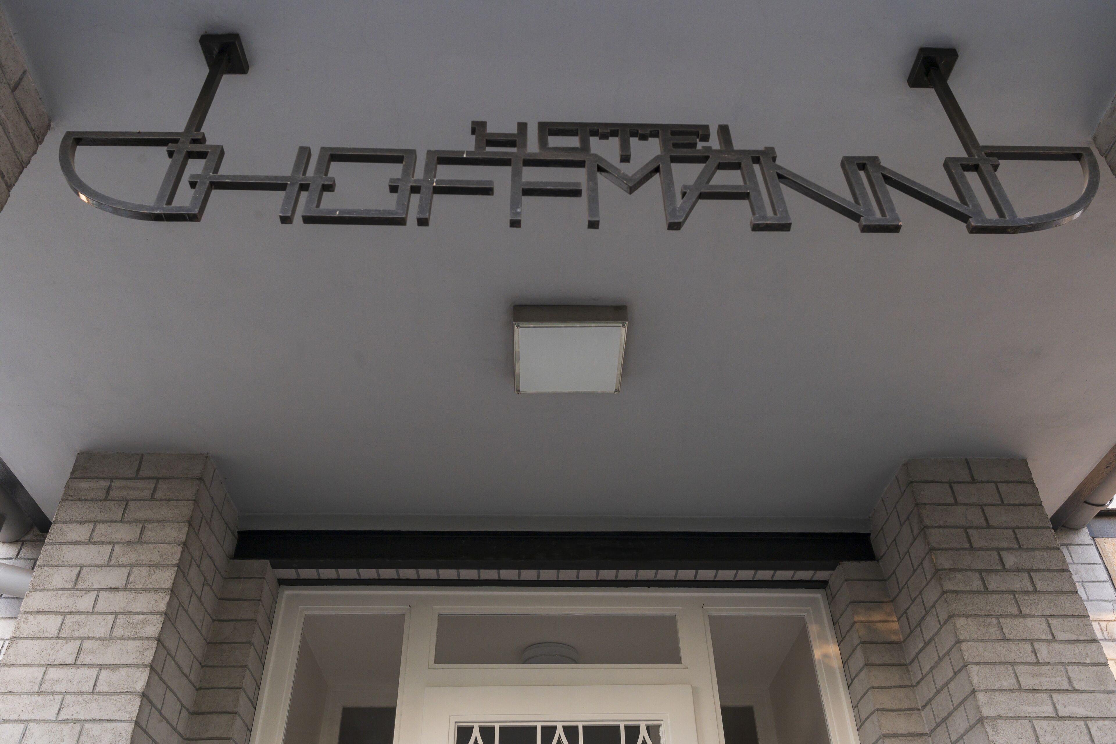 A hotel sign with the name "HOTEL GOFFMAN" in a modern, metallic design.