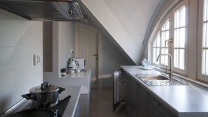 A modern kitchen with a built-in stove, a sink, and a window providing natural light.