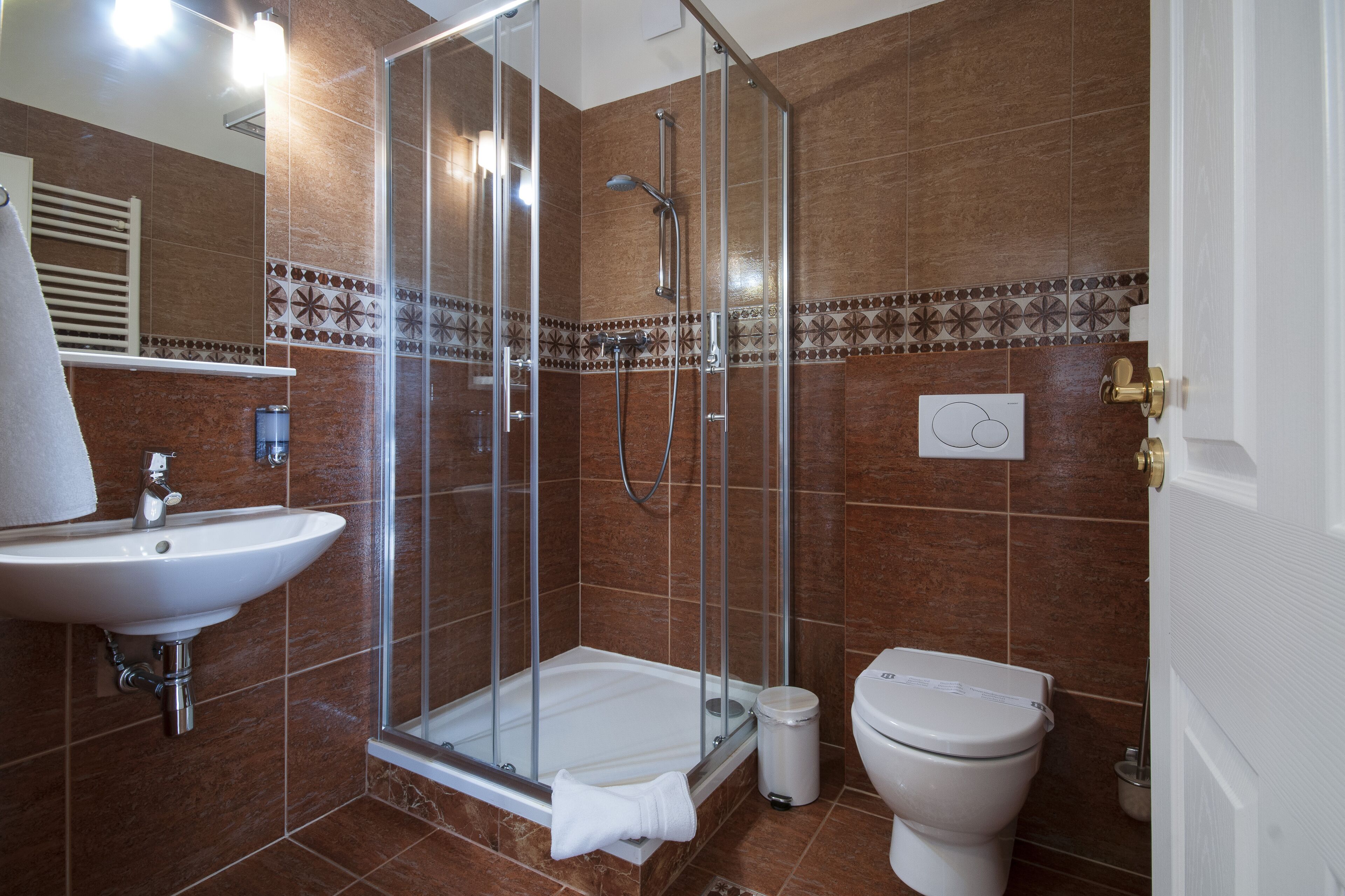 Une salle de bain avec une douche à parois de verre, un lavabo et des toilettes.