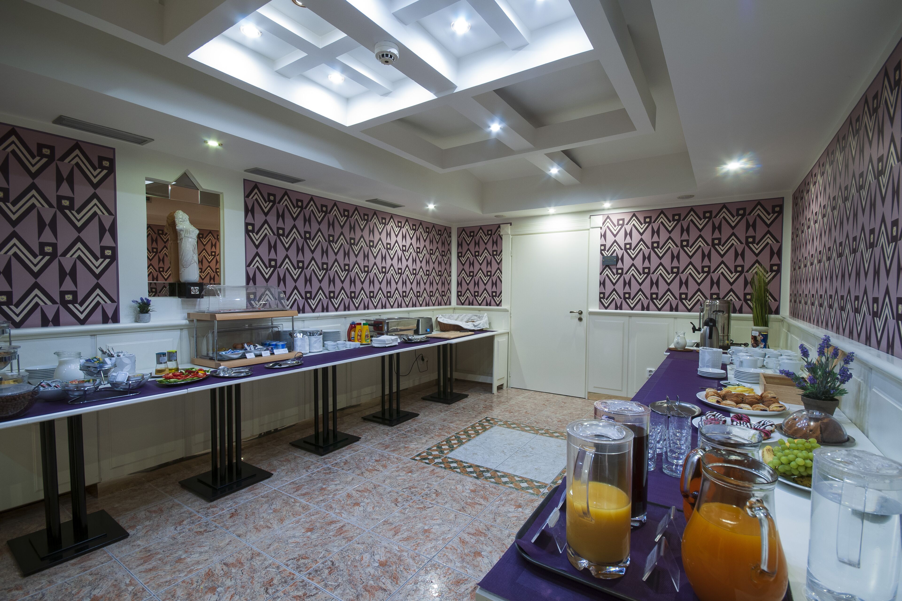 A buffet setup with a variety of food items, a coffee station, and a juice bar.