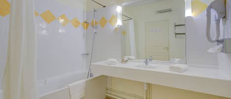 Un baño con bañera, dos lavamanos, un espejo grande y ducha.
