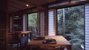 A traditional Japanese-style room with tatami flooring, low tables, and sliding doors.