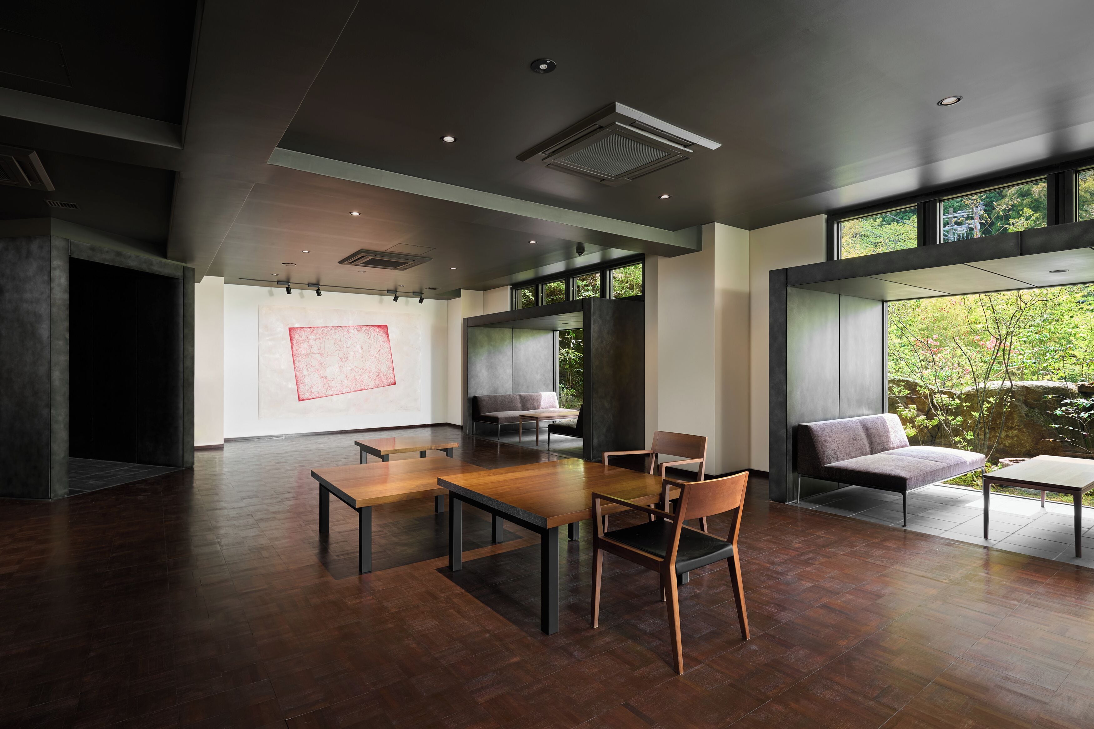 A modern interior with a dining area, seating, and large windows.