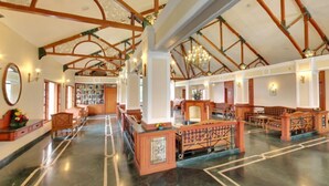 A spacious hall with high ceilings, wooden beams, and chandeliers. - KTDC Tea County Munnar (Devikolam)