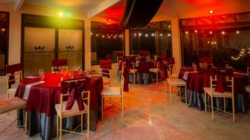 A restaurant with tables set for dining, featuring a red and black color scheme.