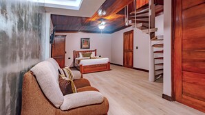 A room with a wooden ceiling, a bed, a sofa, and a staircase. - Hotel Villa Florencia (Turrialba)