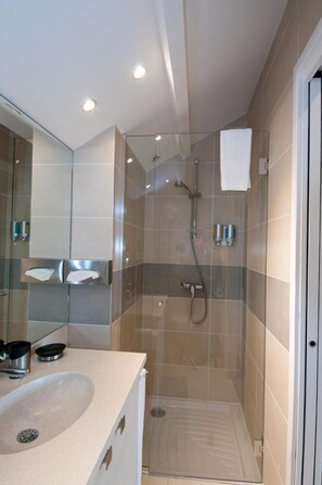 A modern bathroom with a glass-enclosed shower, a sink with a mirror, and a towel hanging on the wall. - Residence Hôteliere la Cerisaie (Saulx-les-Chartreux)