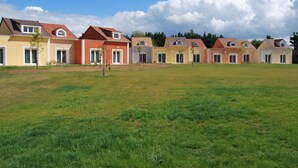A row of houses with a grassy field in front.