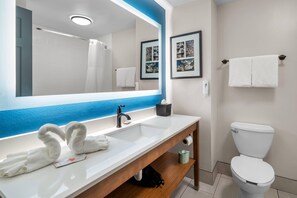 A bathroom with a white sink, a mirror, a toilet, and a towel rack. - Country Inn & Suites by Radisson, Port Orange-Daytona, FL (Port Orange)