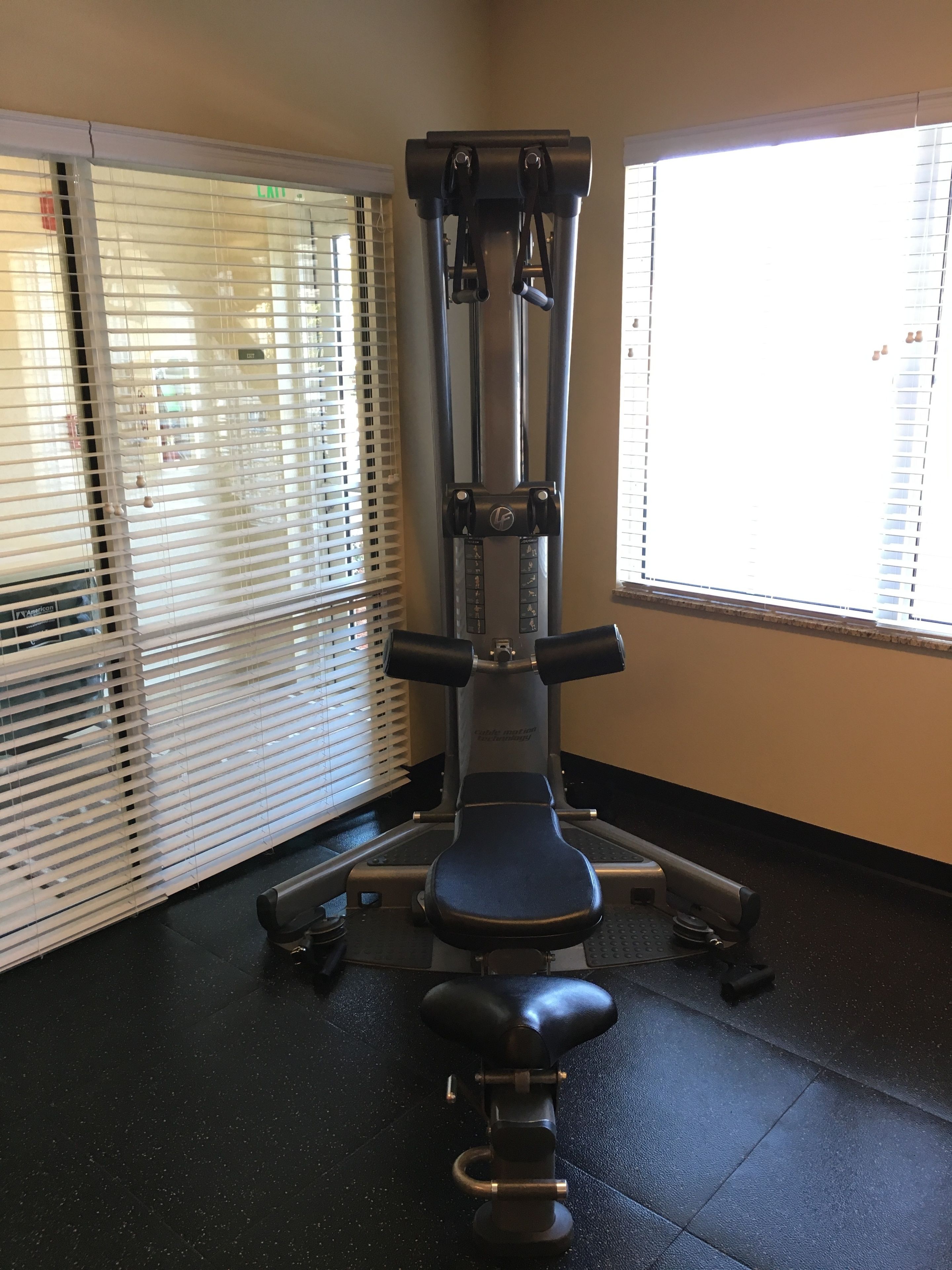A gym with a pull-up bar, bench press, and weight stack.