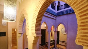 A courtyard with arches, a staircase, and a balcony with a railing. - Riad Marrakiss (Marrakech)