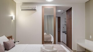 Ein Hotelzimmer mit Bett, Nachttisch und Klimaanlage.