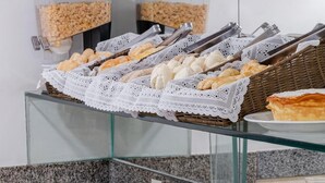 Ein Buffet mit verschiedenen Speisen, darunter Gebäck, Früchte und Getränke.