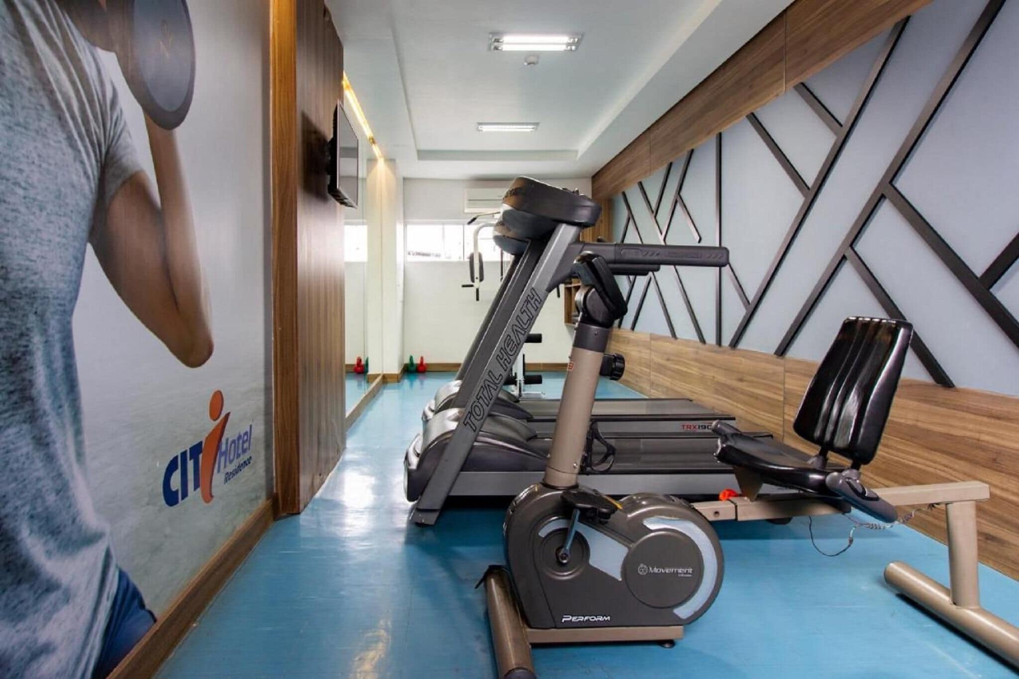 A gym with treadmills, a stationary bike, and a rowing machine.