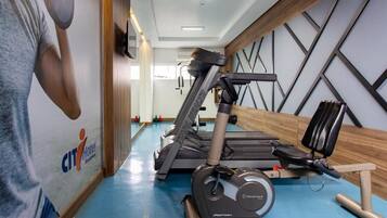 A gym with treadmills, a stationary bike, and a rowing machine.