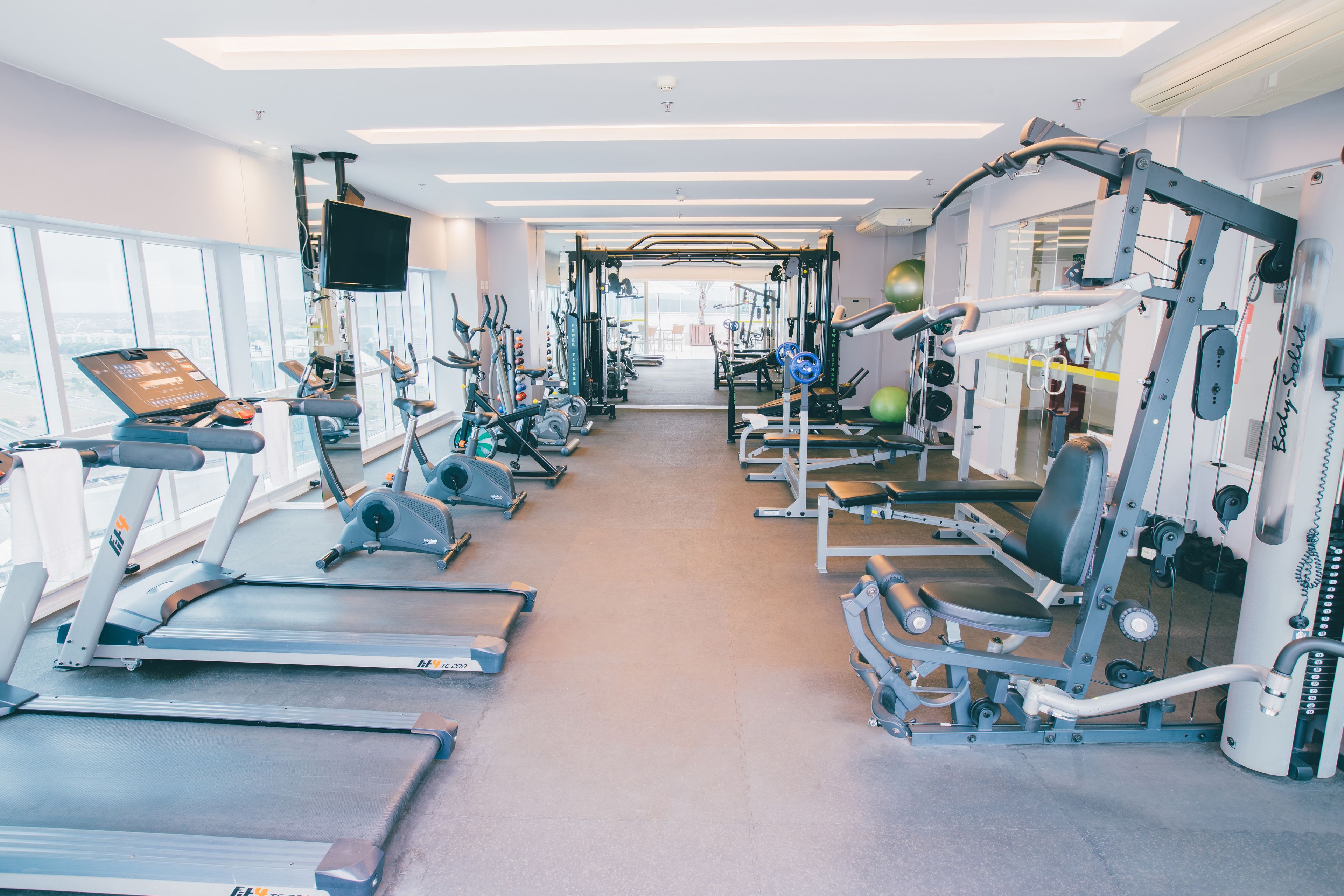 A gym with treadmills, weight machines, and exercise balls.