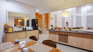 A modern kitchen with a central island, wooden cabinets, and a large mirror. - Camboriú Express (Balneário Camboriú)
