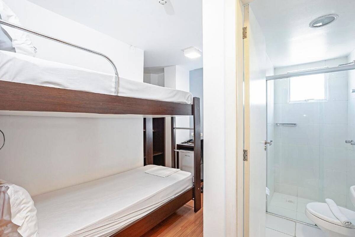 A bunk bed room with a shower area.