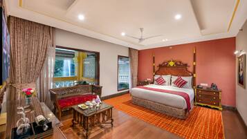 A spacious bedroom with a large bed, a wooden nightstand, a bedside table, and a view of a balcony.