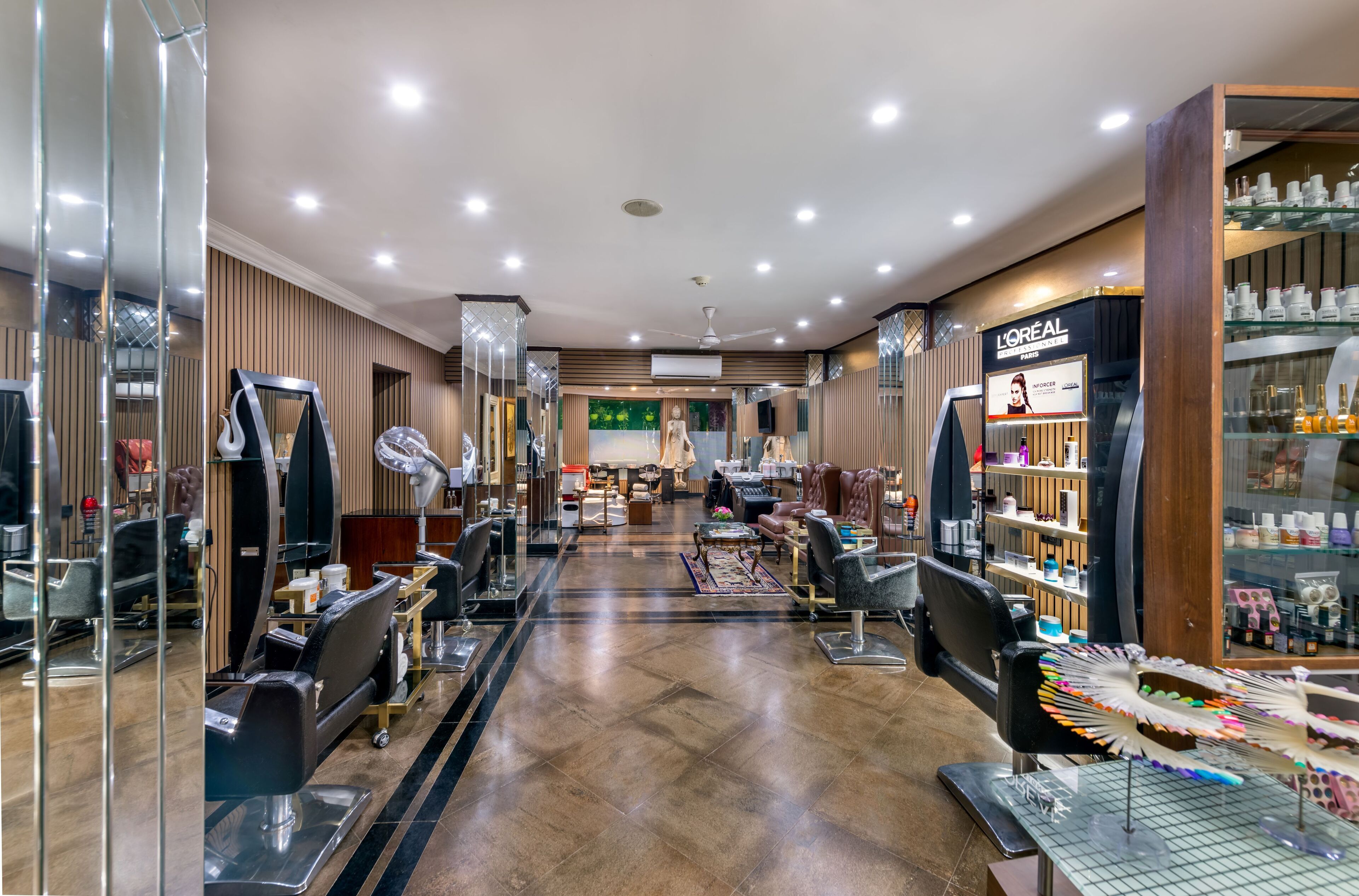 A well-lit salon with multiple hairdressing stations, a L'Oréal Paris sign, and a variety of hair care products on display.