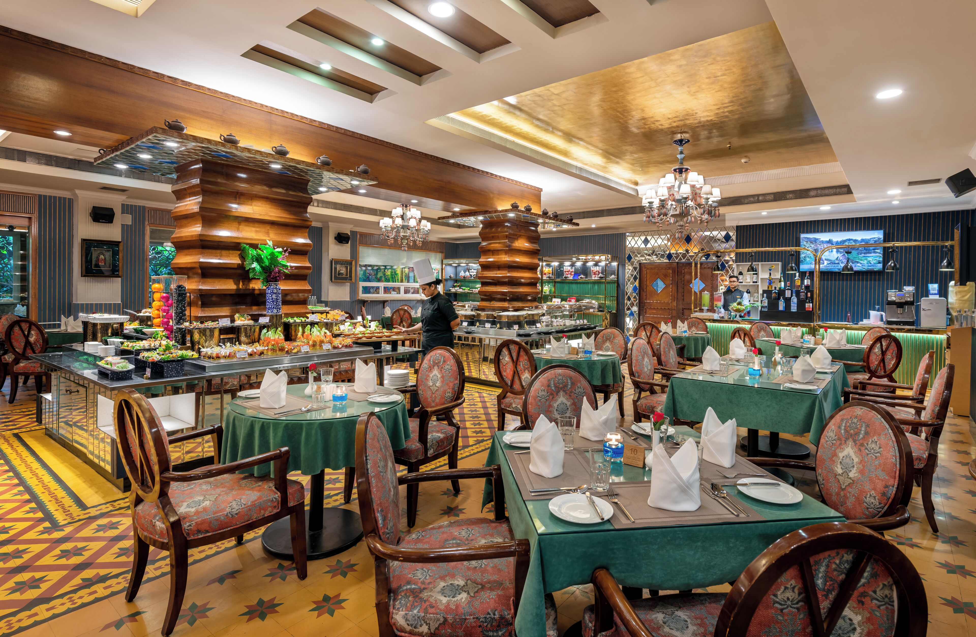 Un restaurante con varias mesas, sillas y una zona de bar.