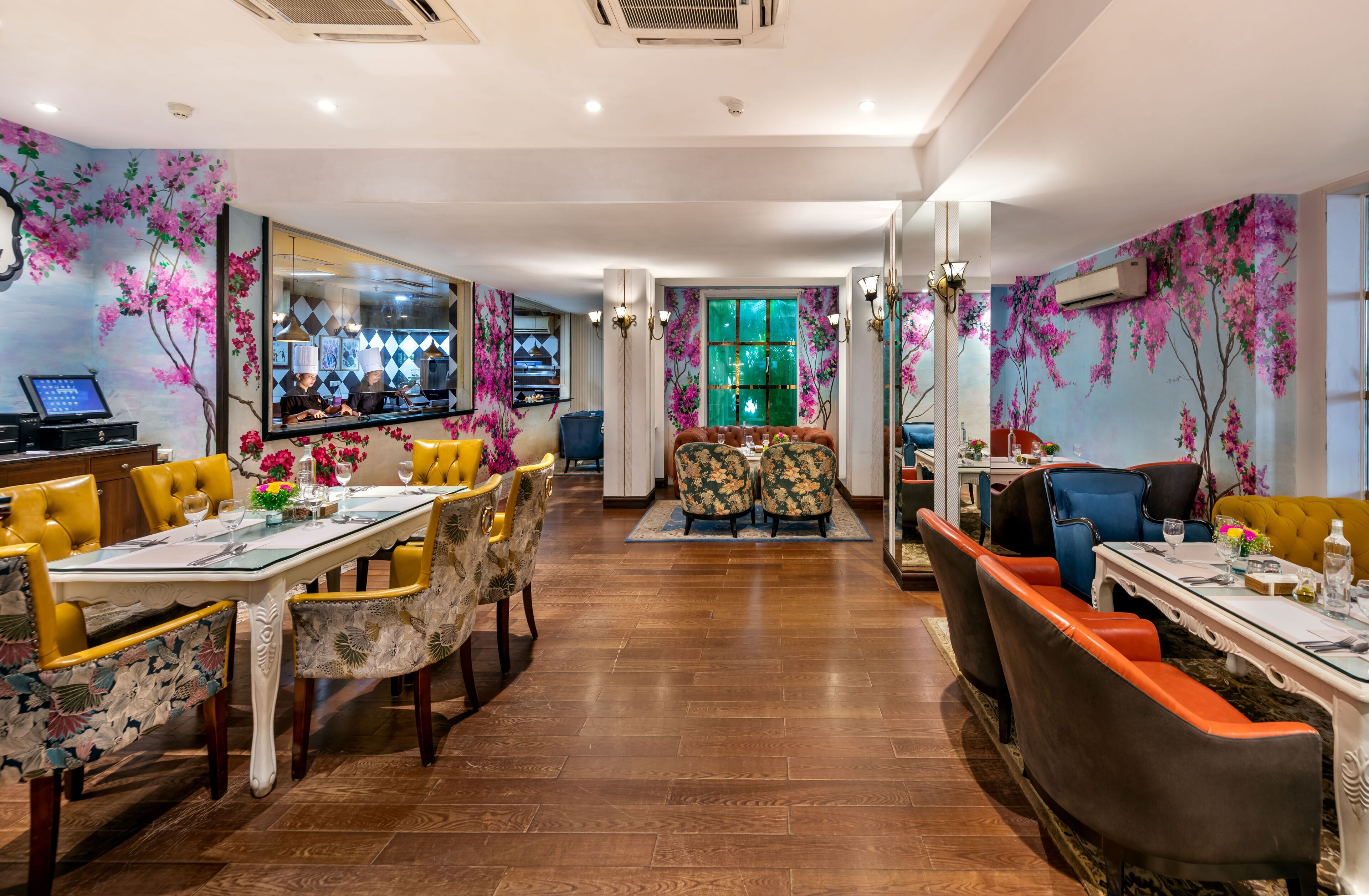 A dining area with a long table, chairs, and a bar in the background.